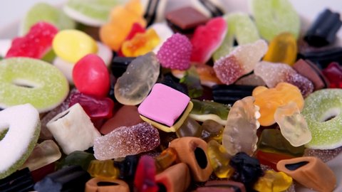 many colored gelatinous sweets, gummy bear, black licorice candies, concept of children's delicacy, healthy and unhealthy food, halal food, pleasant diet, selective focus at shallow depth of field