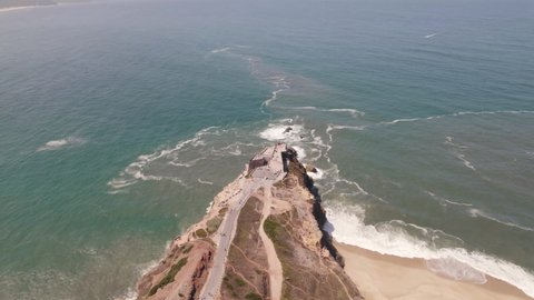 Aerial High view Seascape Landmark Lighthouse on cliffside, Nazaré - Portugal