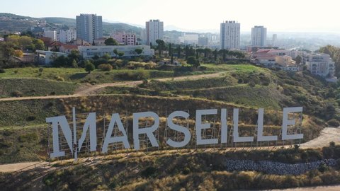 France, Marseille, giant letters like the Hollywood sign at the top of Grand Littoral hill. Backward drone aerial view. Former city of Bernard Tapie.
