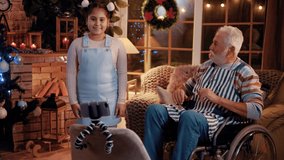Teenager little girl and grandfather in a wheelchair  shooting together dancing when making video for social media
