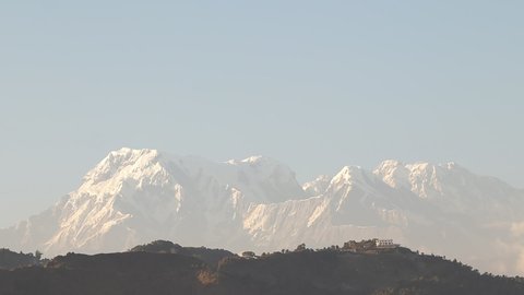 Beautiful sunset view of clouds rolling over the Himalayas in the Pokhara valley of Nepal. Timelapse of Mt. Machchapuchhre or Fishtail during morning hour.
