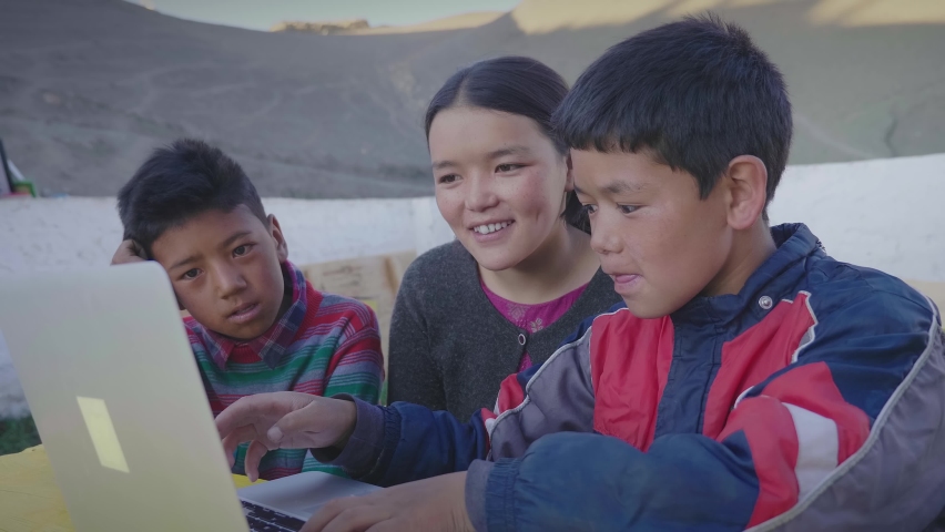 Three young East Asian rural kids sitting together outdoors and attending an online class or tuition are engrossed using a laptop in the mountainous rural village. Remote or distance education concept | Shutterstock HD Video #1081445768