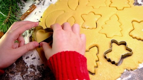 Xmas biscuits. Close Up Of Child Hands Making Gingerbread Cookie. Family Spending Time Together At Home. Christmas And New Year Concept Slow-Mo.  