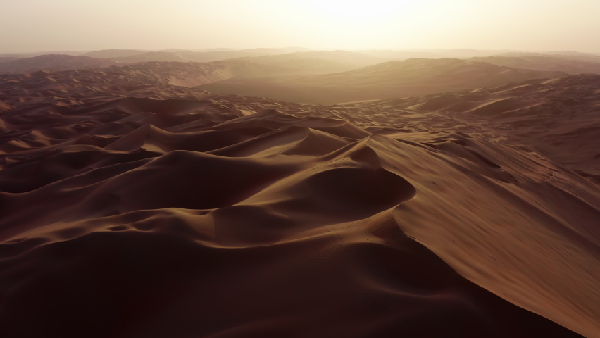 Drone flying over massive sand dunes at sunrise. Aerial bird view of desert landscape. Liwa desert, Abu Dhabi, United Arab Emirates. Epic cinematic background of arabic nature. Royalty-Free Stock Footage #1081455428