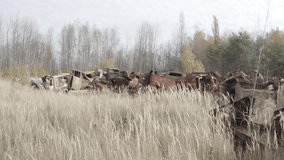 Aerial video. Old abandoned equipment that took part in the elimination of the accident. The village of Rassokha. Chernobyl. Rusty machinery. 