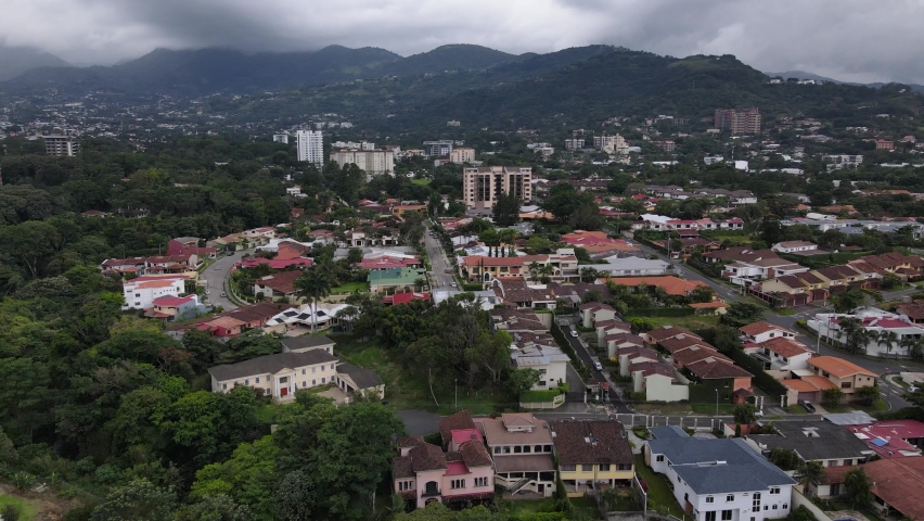 Aerial shot flying over San Jose city and Escazu mountain range, Costa Rica