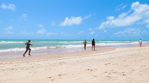 Recife, PE, Brazil - October 14, 2021: bathers at Boa Viagem beach. People enjoying the day at the beach on a beautiful sunny day. Pan right video movement.