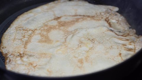traditional russian thin pancakes called blini preparation on kitchen pan, closeup shot