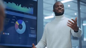 Diverse Office Product Presentation: Successful Black Digital Entrepreneur Uses TV Screen with Big Data, Statistics, Talks about Company Growth, Discusses Strategy with Investors, Managers, Executives - Powered by Shutterstock - Get 15% off with code: PIKWIZARD15