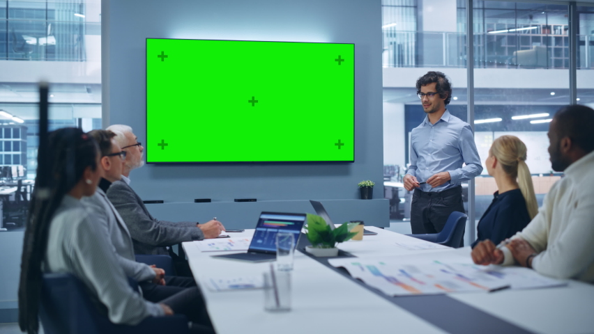 Office Conference Room Meeting Presentation: Charismatic Latin Businessman Talks, Uses Green Screen Chroma Key Wall TV. Successfully Presenting a e-Commerce Product to Group of Multi-Ethnic Investors | Shutterstock HD Video #1081470230