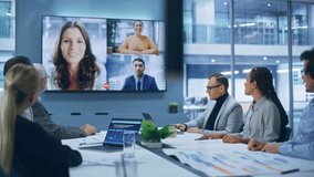 Video Conference Call in Office Boardroom Meeting Room: Executive Directors Talk with Group of Multi-Ethnic Entrepreneurs, Managers, Investors. Businesspeople Discuss e-Commerce Investment Strategy