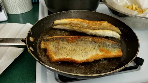 Home cooking - Frying or cooking two fillets of walleye or Yellow Pike with skin on non stick pan. Fish was previously battered in flour.