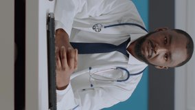 Portrait of african american physician doctor sitting at desk analyzing disease diagnostic report typing medical expertise on computer. Therapist man working at healthcare treatment in hospital office
