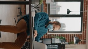 Business man doing paperwork and looking at rate charts while working with laptop. Employee wearing face mask and analyzing data analysis on files for project planning and strategy. - Powered by Shutterstock - Get 15% off with code: PIKWIZARD15