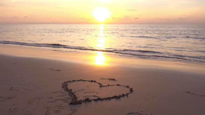 Heart symbol on beach, Hand drawn heart on beach sand over sunset or sunrise sky beautiful light nature landscape