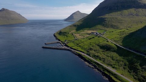 Beautiful cinematic aerial footage of the small ferry pier and town if Sydradalur in Kalsoy, on the Faroe Islands