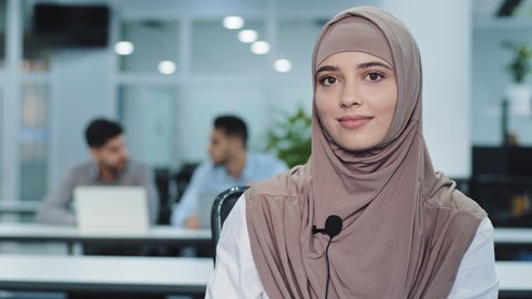 Closeup beautiful young indian arabic businesswoman using modern microphone, audio equipment involved in video call conversation negotiation or passing online job interview, distant communication