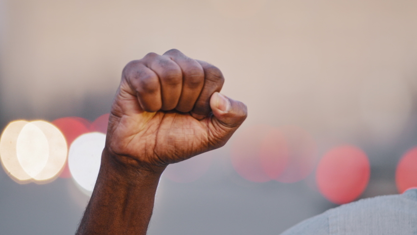 Closeup strong clenched male fist raised up. Black African American adult mature man demonstrates protests against discrimination showing with hand gestures against racism discrimination solidarity Royalty-Free Stock Footage #1081486733