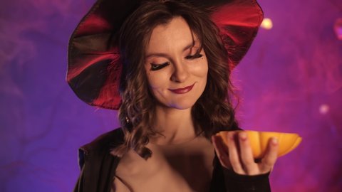 beautiful witch cuts a pumpkin for halloween. High quality 4k footage