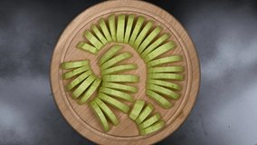 Sliced zucchini on a wooden kitchen board. Top view. Loop motion. Rotation 360. 4K UHD video footage 3840X2160.