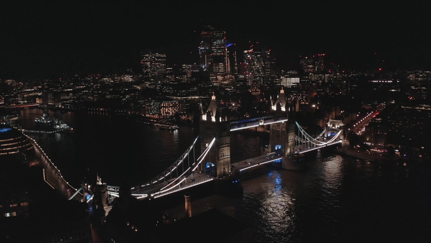 Aerial view to the illuminated Tower Bridge and skyline of London at night, UK. City lights of London.