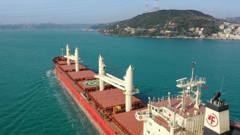 ISTANBUL - CIRCA 2020: Flyover of dry cargo ship underway. Red bulk carrier cruising along Bosphorus. FEDERAL BARENTS a merchant ship designed to transport bulk cargo such as grains ore coal or timber