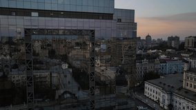 A business center at sunset. Reflection of the city in the windows of a glass building in the city center. Slow flying drone past the glass wall. Sunset in the reflection of a business center - Powered by Shutterstock - Get 15% off with code: PIKWIZARD15