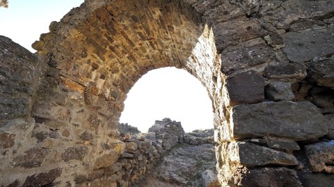 Ruins of ancient stone castle. Sun light entering through arch