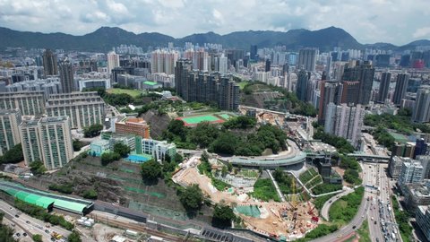 A railway and subway station railroad cover residential project built on a hillside slope in Ho Man Tin, aerial View of the skyline of Hong Kong at Victoria Harbour Financial Kowloon Peninsula