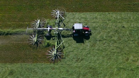 Aerial view of a tractor mowing a green grass