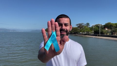 man holding prostate cancer prevention symbol, blue november, prostate exam, men's touch exam, campaign against prostate cancer