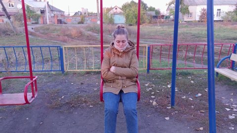 Sad woman on a swing slow motion outdoors portrait