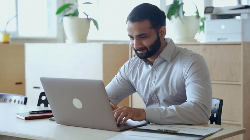 Ethnic indian business man entrepreneur investor manager using computer, watching webinar working in office analyzing online data market thinking doing web research looking at laptop. Royalty-Free Stock Footage #1081513598