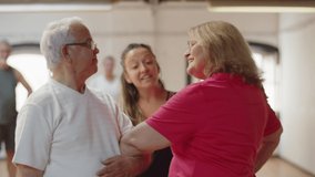 Medium shot of mature couple learning dance with instructor. Cute senior man and woman practicing movement to perfection in dance studio, swinging, holding each other elbow. Occupation, hobby concept - Powered by Shutterstock - Get 15% off with code: PIKWIZARD15