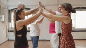 Senior people playing oranges and lemons in dance studio. Side view of group of mature women and men exercising with young dance teacher in ballroom, having fun together. Free time, hobby concept - Powered by Shutterstock - Get 15% off with code: PIKWIZARD15
