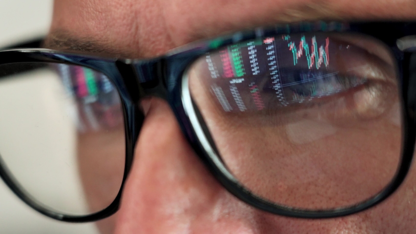 Focused crypto trader analyst wearing eyeglasses working looking at computer screen reflecting in glasses analyzing online trading stock exchange market data charts. Close up eye reflection. Royalty-Free Stock Footage #1081515695