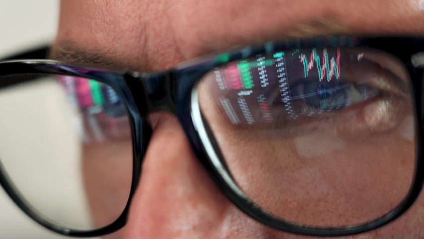 Focused crypto trader analyst wearing eyeglasses working looking at computer screen reflecting in glasses analyzing online trading stock exchange market data charts. Close up eye reflection. | Shutterstock HD Video #1081515695
