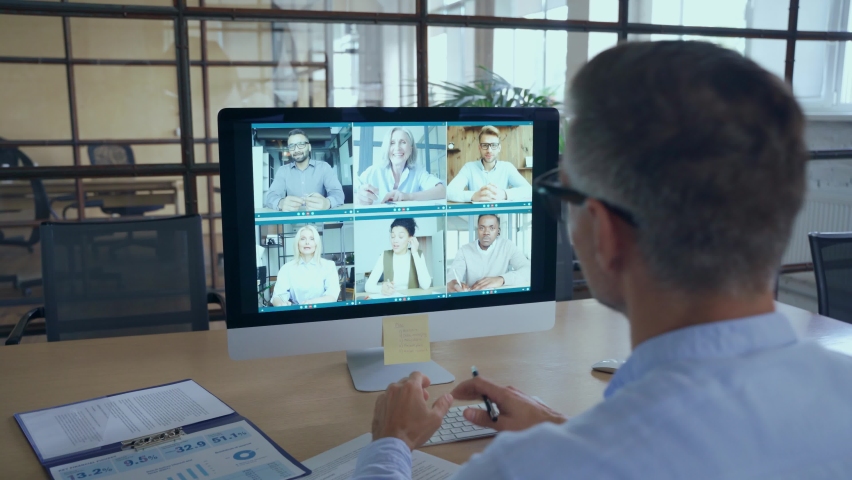 Business man talking with diverse team people having digital group video call global conference working leading online virtual meeting training on pc computer. Over shoulder videocall screen view Royalty-Free Stock Footage #1081515710