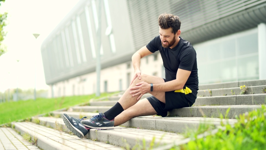 young Caucasian runner athlete with muscle pain. Man massaging Stretching, trauma injury while jogging outdoors. Fitness male sprain severe pain stretch pull. Leg muscle cramp calf sport Royalty-Free Stock Footage #1081516082