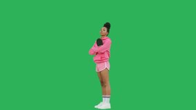 Young sporty woman table tennis player with racket over green background. Portrait of girl wearing pink hoodie and shorts looking at camera. Chroma key. 4k raw video footage