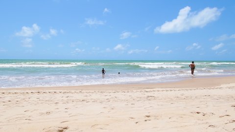 Recife, PE, Brazil - October 14, 2021: bathers at the beach of Boa viagem. People enjoying the day at the beach on a beautiful sunny day. Pan right video movement.