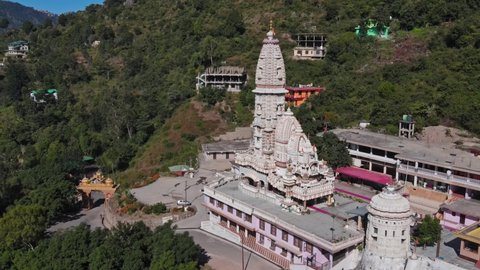 4k Aerial view of Jatoli Shiv Parvati Temple in Himachal Pradesh, India. Drone shot of Asia's highest Shiv temple. A beautiful and colourful architecture amidst green mountains on a sunny clear day.