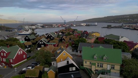 Beautiful cinematic aerial footage of the City of Torshavn Capital of Faroe Islands- View of Cathedral, colorful buildings, marina, suburbs and Flag