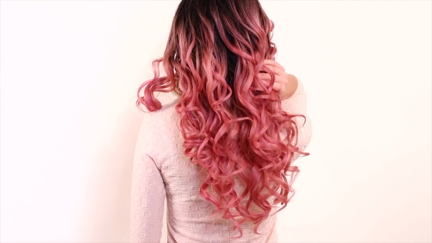 Beautiful long trendy pink ombre dyed curly Hair. Beauty woman with luxurious wavy black and pink gradient color hair. Brunette model girl with healthy Hair. Hairstyle, cure, extensions. Slow motion | Shutterstock HD Video #1081528145