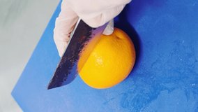 The chef cuts a juicy orange with a knife. Healthy food concept. Vertical video

