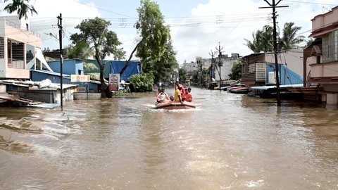 KOLHAPUR-INDIA - JULY 24, 2021: Rescue workers use inflatable raft to evacuate residents from flooded area in Ichalkaranji after heavy monsoon rains in western Maharashtra