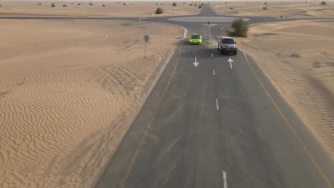 expensive and luxurious cars drive along the road. lamborghini and rolls royce cars in UAE. half desert road 2021.07.15