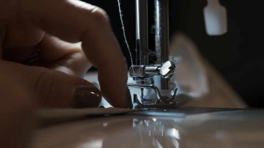 Needle for sewing machine in motion. The close-up of the sewing machine needle quickly moves up and down. The seamstress sews gray fabric in the sewing workshop. The process of sewing the fabric.	 Royalty-Free Stock Footage #1081545863