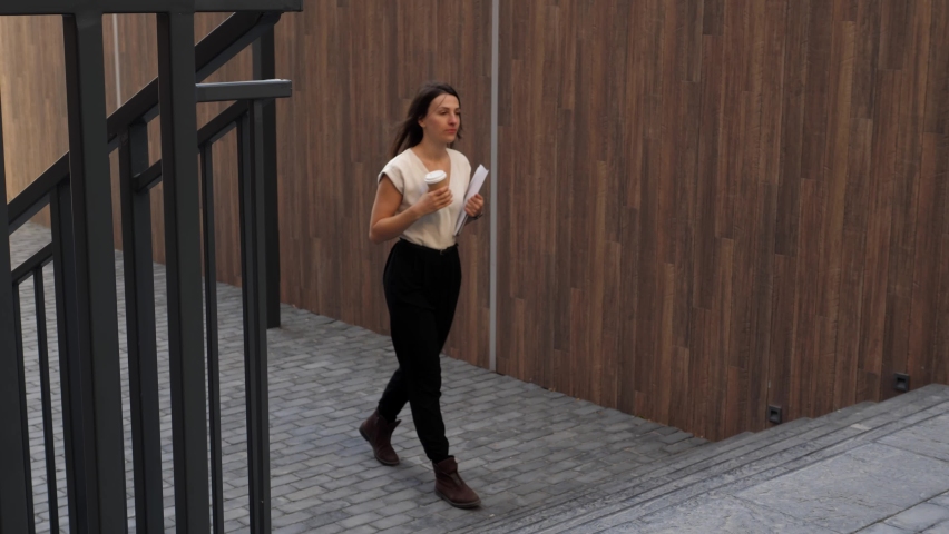 Young business woman rushes to a meeting. A beautiful lady in office clothes who is late for work, a business meeting, business negotiations.