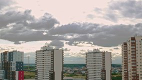 Time-lapse video clouds over the city, multi-storey buildings with apartments and one-story residential buildings in the city, clouds fly over the city and form.